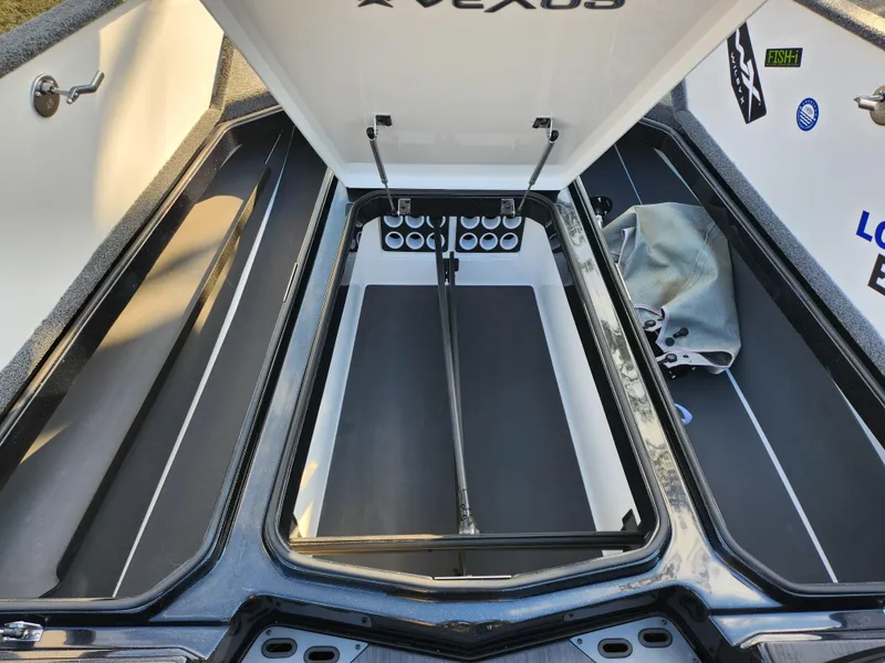 Slide: The Image of 2023 Vexus VX20 boat storage compartments with open lids and organized interior layout. - 16