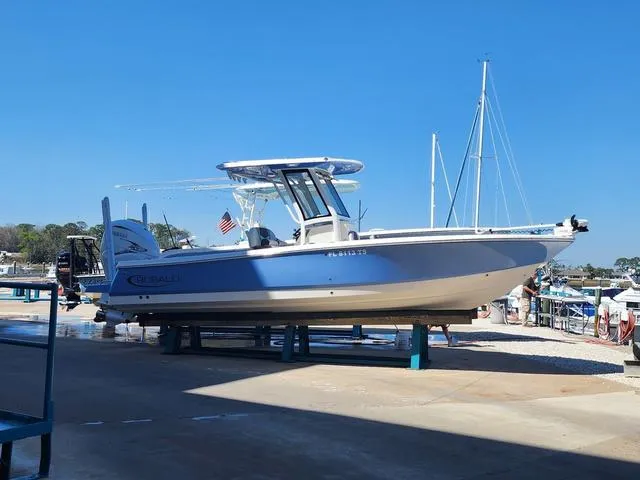 Slide: The Image of 2023 Robalo 266 Cayman boat on stand, featuring dual outboard engines. - 1