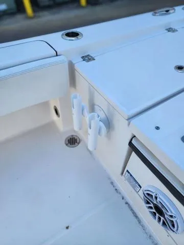 Slide: The Image of 2023 Robalo 266 Cayman boat near a marina building under clear blue sky. - 13