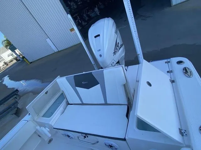 Slide: The Image of 2023 Robalo 266 Cayman boat with T-top, docked near a warehouse. - 14