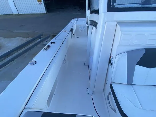 Slide: The Image of 2023 Robalo 266 Cayman boat docked at a marina with clear blue skies. - 17