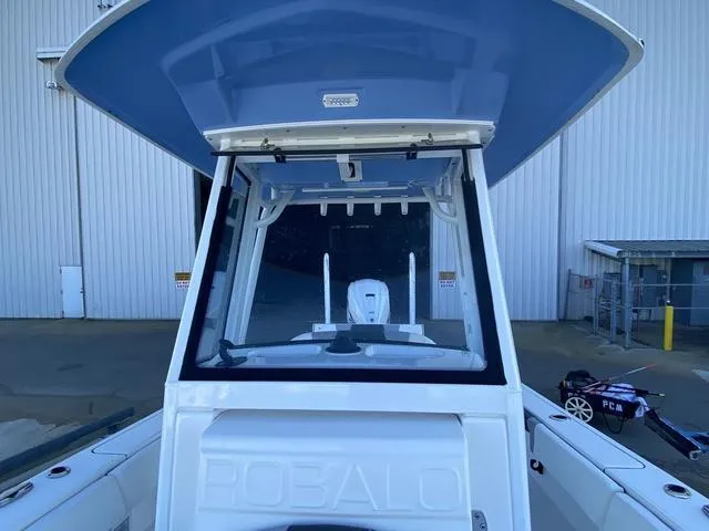 Slide: The Image of 2023 Robalo 266 Cayman boat dashboard with steering wheel and control panels. - 22