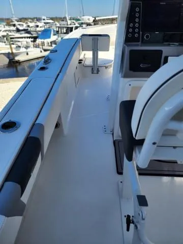 Slide: The Image of 2023 Robalo 266 Cayman boat interior with cushioned seating and branded mat. - 23