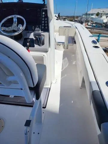 Slide: The Image of 2023 Robalo 266 Cayman boat interior with seating and motor, docked at a marina. - 24