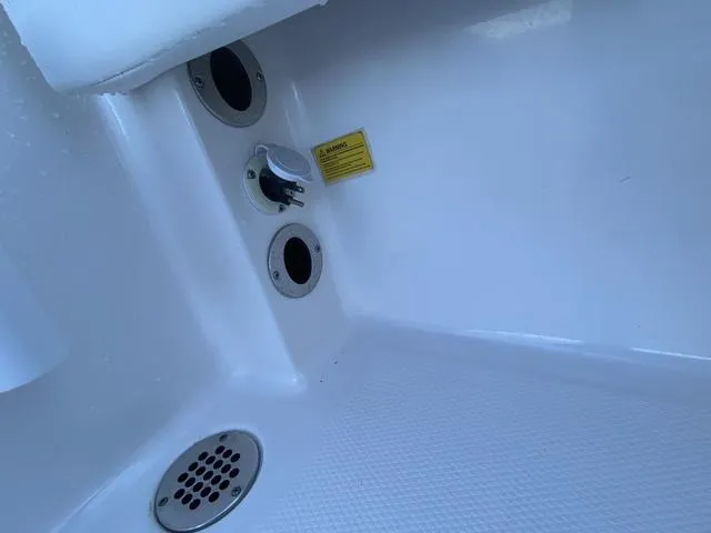 Slide: The Image of 2023 Robalo 266 Cayman boat with open storage compartments and outboard motor. - 25