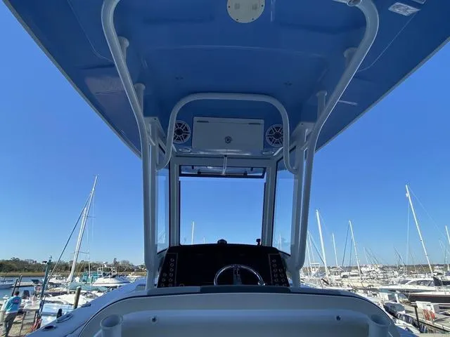 Slide: The Image of 2023 Robalo 266 Cayman boat storage compartment with open hatch and visible wiring. - 27