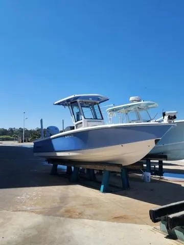 Slide: The Image of 2023 Robalo 266 Cayman boat in blue, docked at Palm Cove Marina. - 3