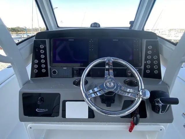 Slide: The Image of 2023 Robalo 266 Cayman boat with equipment cart in a marina setting. - 30