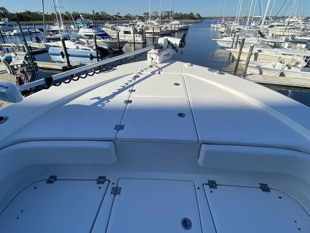 Slide: The Image of 2023 Robalo 266 Cayman boat deck at marina with multiple boats docked. - 41