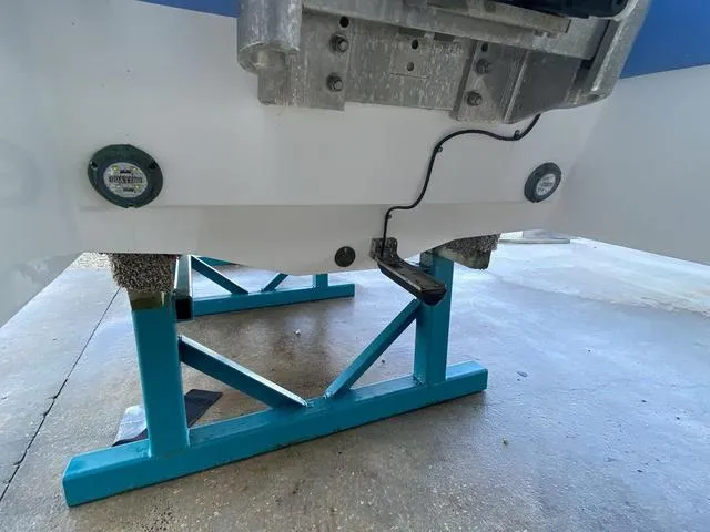 Slide: The Image of 2023 Robalo 266 Cayman boat on blue stands, showing hull details. - 45