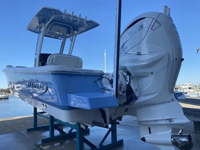 Slide: The Image of 2023 Robalo 266 Cayman boat in marina, blue hull, sunny day. - 5