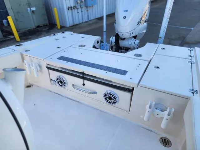 Slide: The Image of 2023 Robalo 266 Cayman boat with open storage compartments at a marina. - 9