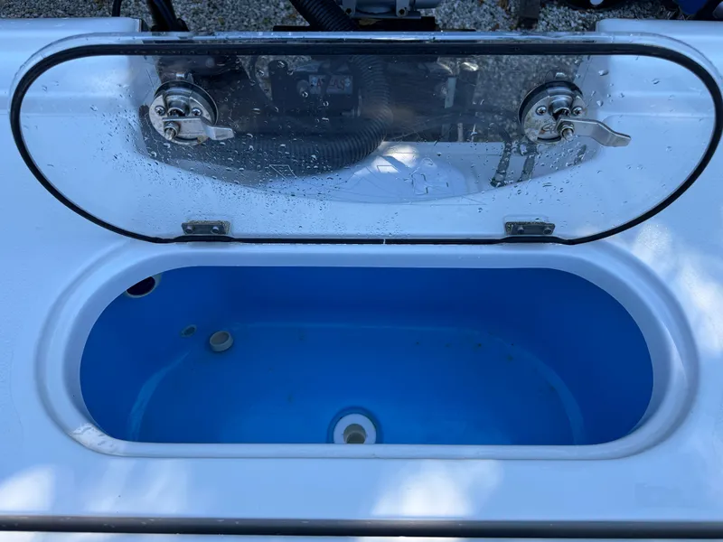 Slide: The Image of Livewell on 2020 Tidewater 2500 Carolina Bay boat, open lid, blue interior. - 13