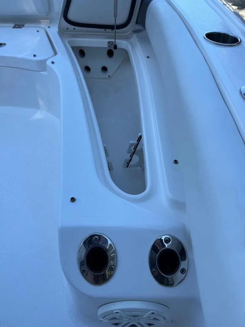 Slide: The Image of 2020 Tidewater 2500 Carolina Bay boat interior detail with storage compartment and cup holders. - 30