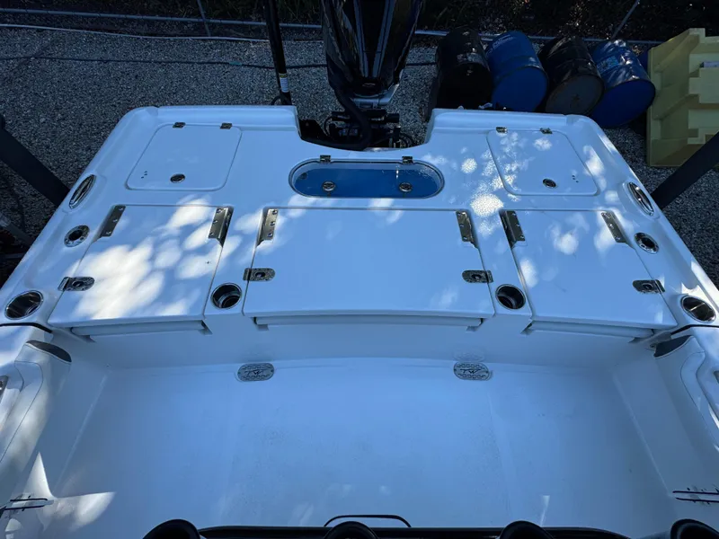 Slide: The Image of 2020 Tidewater 2500 Carolina Bay boat deck with storage compartments and motor. - 9