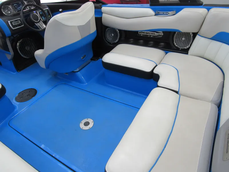 Slide: The Image of 2012 Malibu Wakesetter 22 MXZ interior with blue and white seating and dashboard. - 3
