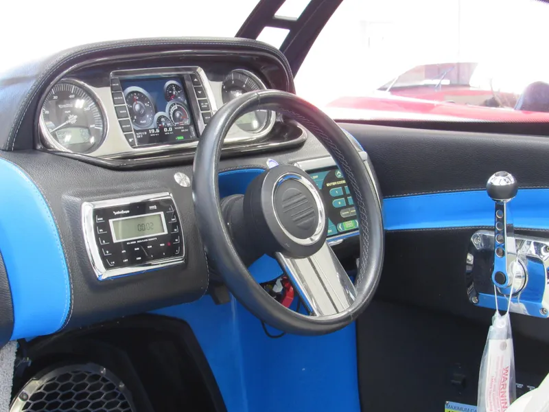 Slide: The Image of 2012 Malibu Wakesetter 22 MXZ dashboard with steering wheel and control panel. - 8