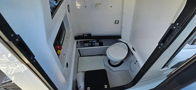 Slide: The Image of 2020 Blackfin 272 CC boat interior with compact marine toilet and control panel. - 18
