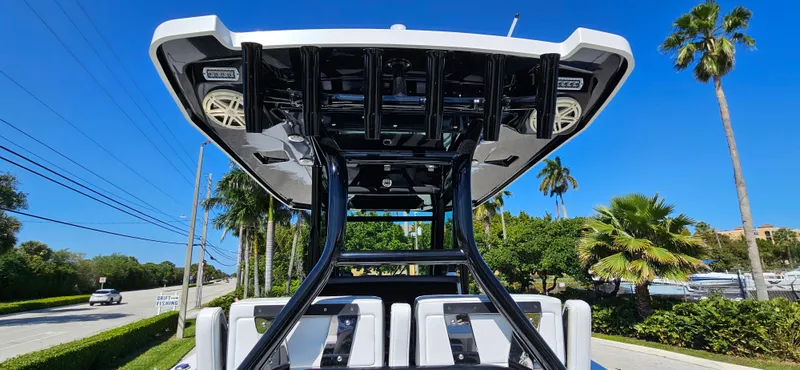 Slide: The Image of 2020 Blackfin 272 CC boat with T-top and speakers, parked near palm trees. - 34