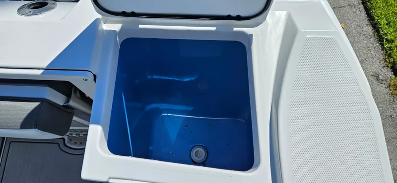 Slide: The Image of 2020 Blackfin 272 CC boat livewell with open lid, showing blue interior. - 35