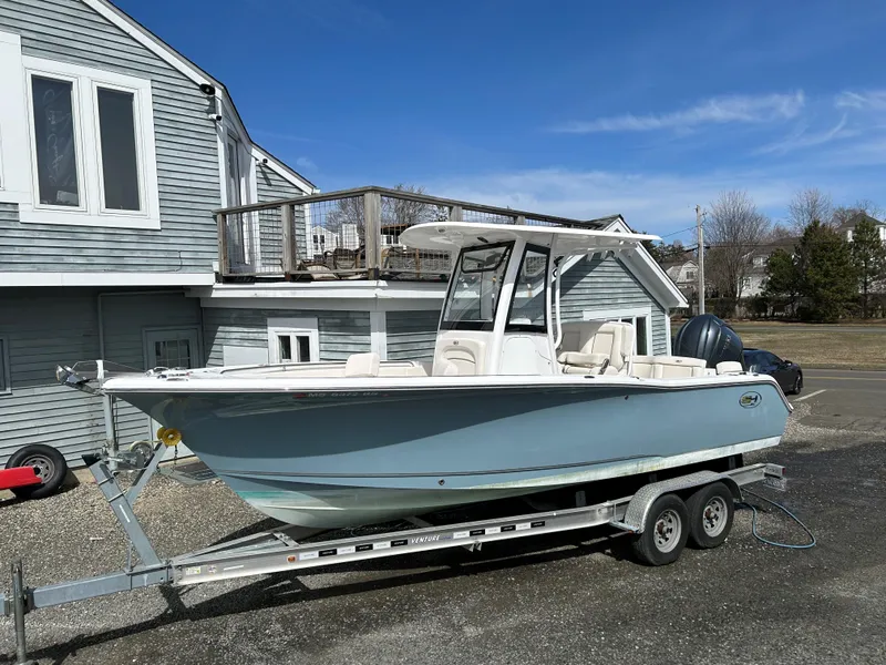 Slide: The Image of 2022 Sea Hunt Ultra 239 SE boat on trailer, parked near a house. - 0