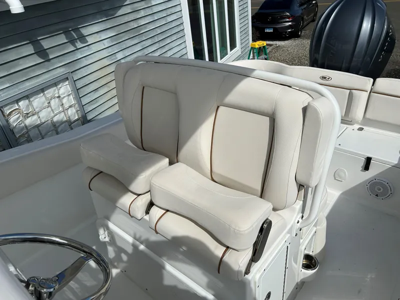 Slide: The Image of 2022 Sea Hunt Ultra 239 SE boat with cushioned seating and steering wheel. - 11