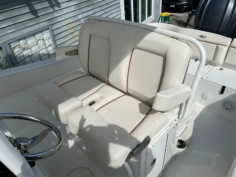 Slide: The Image of 2022 Sea Hunt Ultra 239 SE boat with comfortable beige seating and steering wheel. - 12