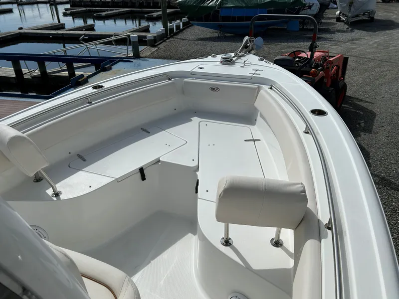 Slide: The Image of 2022 Sea Hunt Ultra 239 SE boat interior at marina, featuring seating and storage. - 15