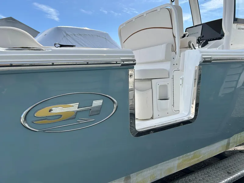 Slide: The Image of 2022 Sea Hunt Ultra 239 SE boat with open side door and logo. - 17