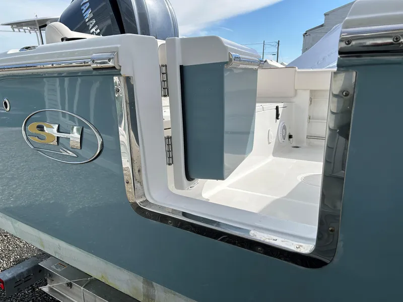 Slide: The Image of 2022 Sea Hunt Ultra 239 SE boat with open side door, showcasing interior details. - 18