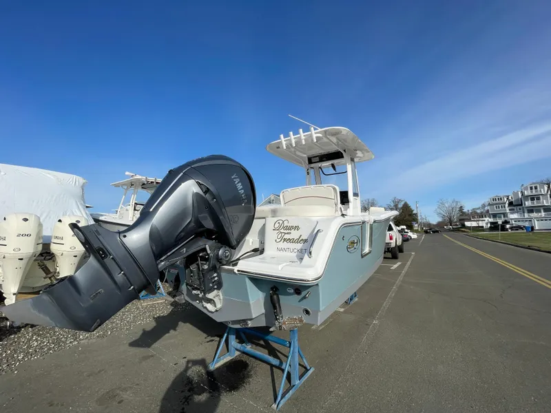 Slide: The Image of 2022 Sea Hunt Ultra 239 SE boat with outboard motor on a trailer, parked outdoors. - 3