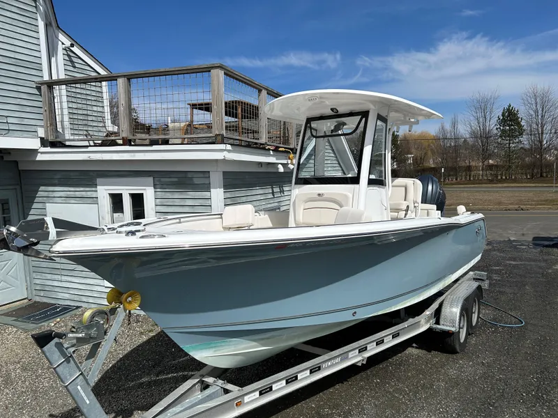 Slide: The Image of 2022 Sea Hunt Ultra 239 SE boat on trailer, parked near a building. - 5
