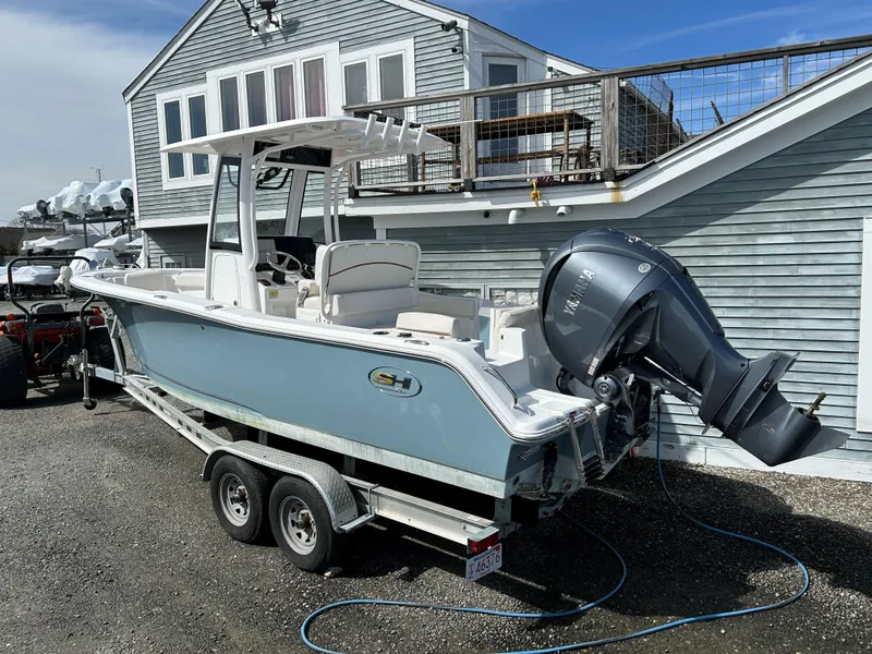 Slide: The Image of 2022 Sea Hunt Ultra 239 SE boat on trailer, parked near a house. - 7