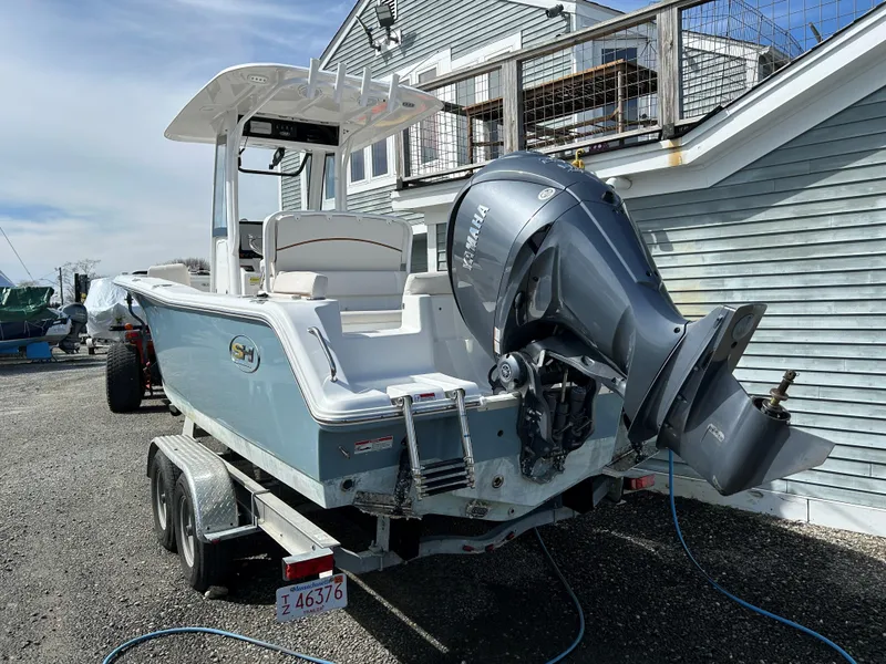 Slide: The Image of 2022 Sea Hunt Ultra 239 SE boat on trailer, parked near a house. - 8