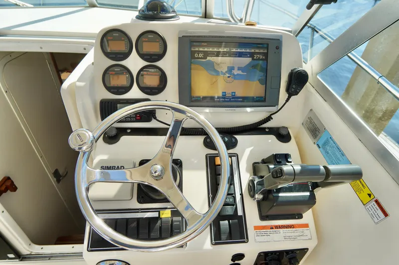 Slide: The Image of 2003 Pursuit 3070 Express boat dashboard with steering wheel, gauges, and navigation display. - 13