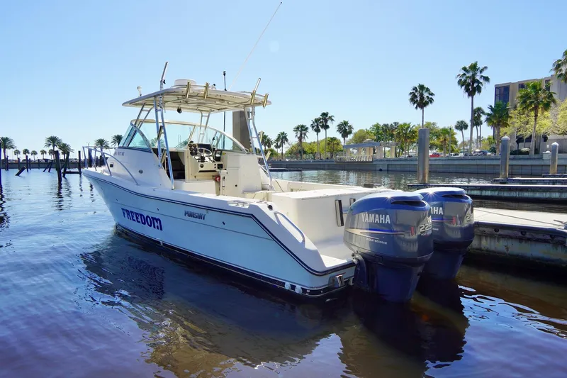 Slide: The Image of 2003 Pursuit 3070 Express boat docked with twin Yamaha engines. - 2