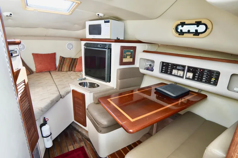 Slide: The Image of Interior of 2003 Pursuit 3070 Express boat with kitchenette and seating area. - 20
