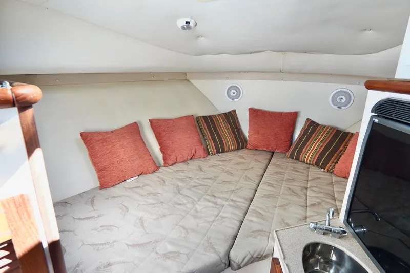 Slide: The Image of 2003 Pursuit 3070 Express cabin interior with cozy bedding and colorful pillows. - 25