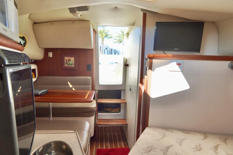 Slide: The Image of Interior of 2003 Pursuit 3070 Express boat with seating, table, and TV. - 27