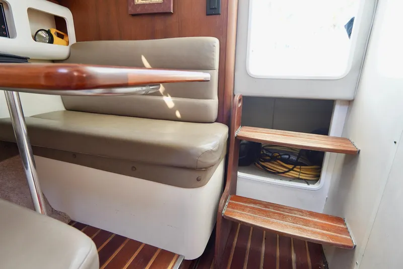 Slide: The Image of Interior of 2003 Pursuit 3070 Express boat with seating and wooden steps. - 28