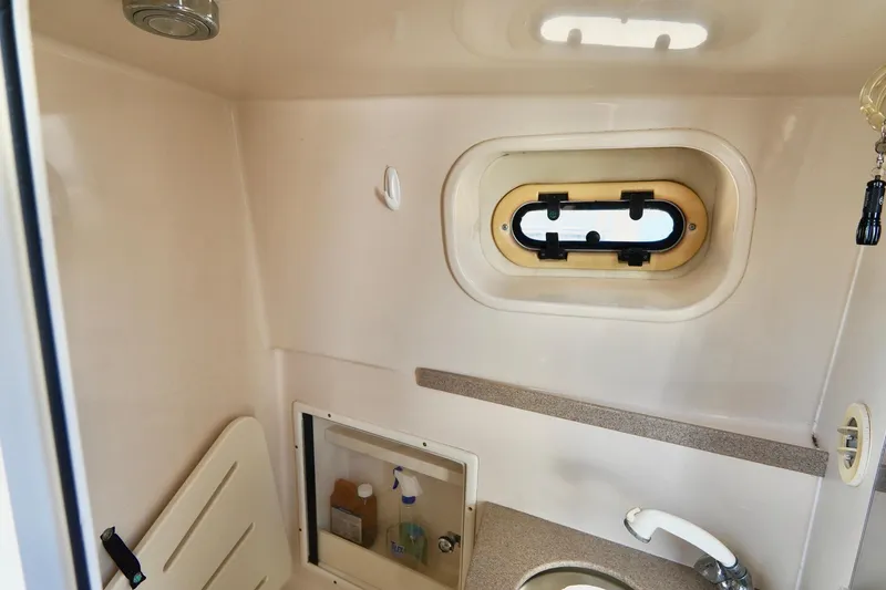 Slide: The Image of 2003 Pursuit 3070 Express boat interior with sink and porthole window. - 29