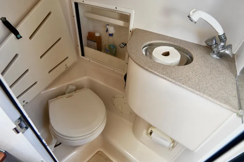 Slide: The Image of Compact bathroom in 2003 Pursuit 3070 Express boat with toilet and sink. - 30