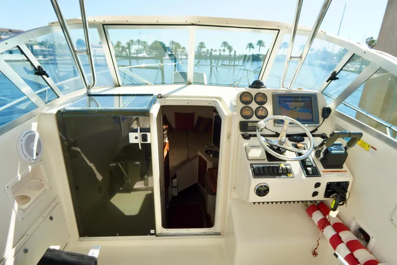 Slide: The Image of 2003 Pursuit 3070 Express boat cockpit with steering wheel and navigation instruments. - 31