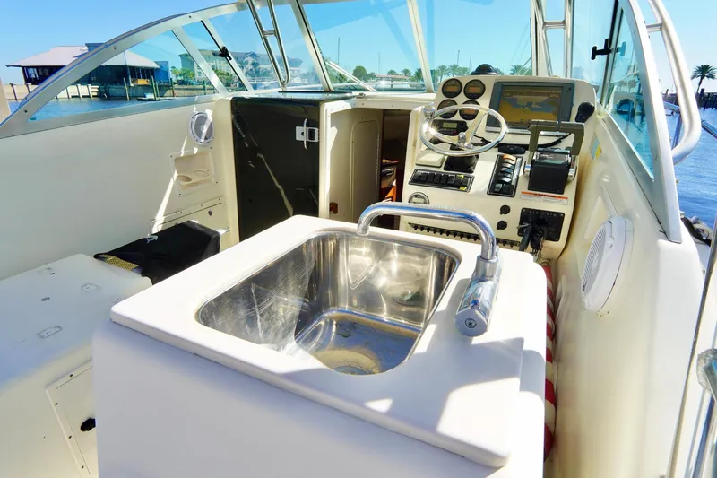 Slide: The Image of 2003 Pursuit 3070 Express boat interior with helm and sink. - 32