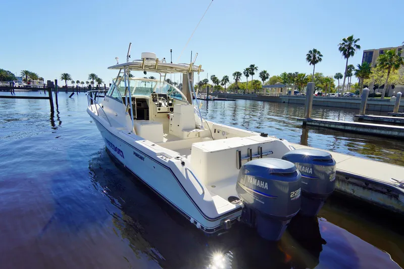 Slide: The Image of 2003 Pursuit 3070 Express boat docked with twin Yamaha engines, sunny marina setting. - 40