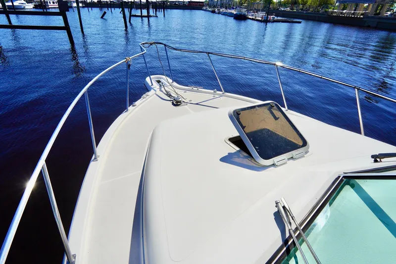 Slide: The Image of 2003 Pursuit 3070 Express boat deck with open hatch, docked by calm waters. - 5