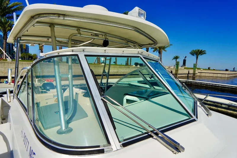 Slide: The Image of 2003 Pursuit 3070 Express boat docked, featuring a sleek design and clear blue sky backdrop. - 7