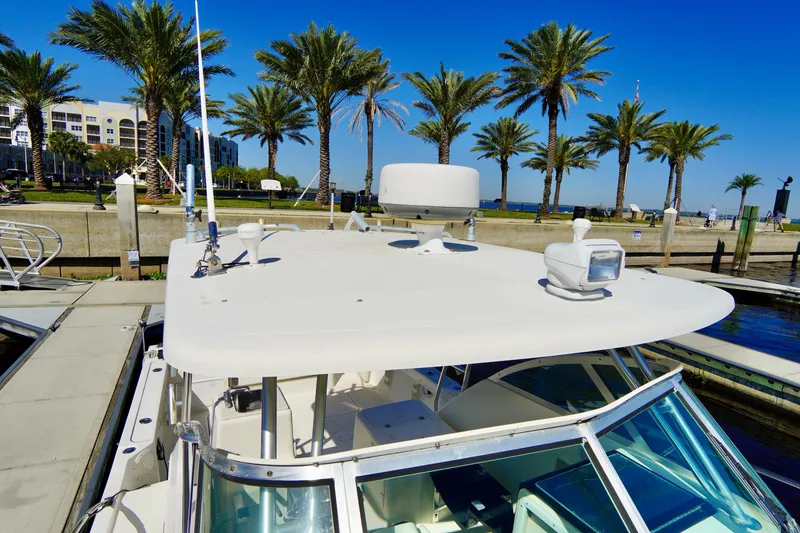 Slide: The Image of 2003 Pursuit 3070 Express boat docked near palm trees under a clear blue sky. - 9