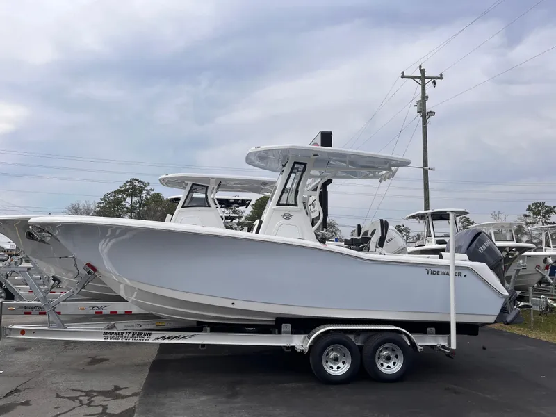 The Image of 2025 Tidewater 232 LXF boat on trailer, side view, cloudy sky background. - 1