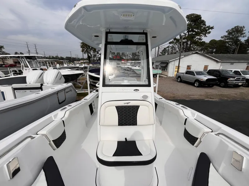 Slide: The Image of 2025 Tidewater 232 LXF boat, white interior, parked at a marina with other boats. - 12